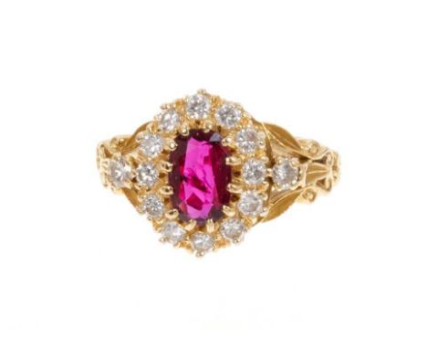 Ruby and diamond cluster ring with an oval mixed cut ruby measuring approximately 8.4mm x 5.4mm x 2.3mm surrounded by a borde