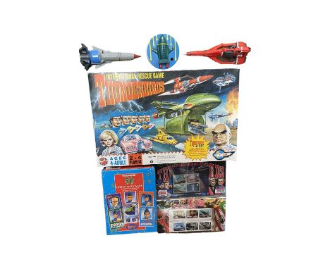 A mixed lot of Thunderbirds memorabilia, to include: - International Rescue Game by Peter Pan Playthings - Box of Woolworths 