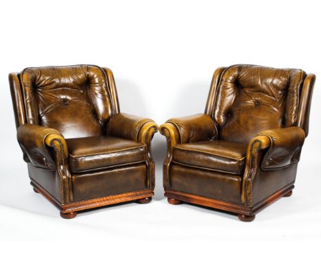 A pair of contemporary leatherette button back armchairs. With slight wings and  scrolled outswept arms with stud work decora