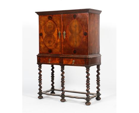 An early 20th century Continental Walnut oyster veneered 18th century style cabinet on stand. The upper section with a two do