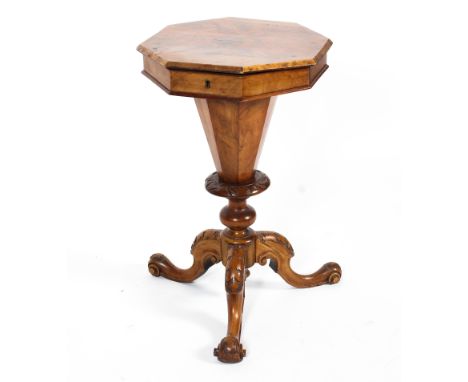 A Victorian walnut sewing box. The octagonal top revealing a fitted interior with shaped compartments and silk covers, on fac
