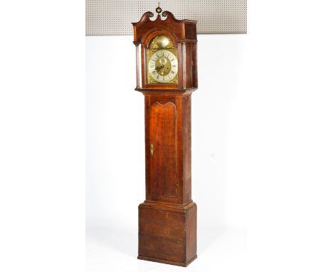 An 18th century oak 8 day longcase clock. The brass and silvered arched dial with applied corner spandrels with subsidiary se