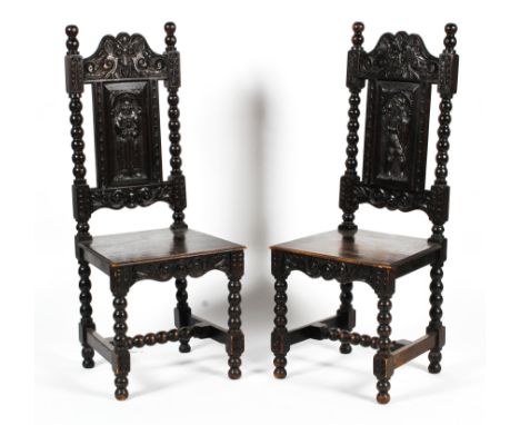 A pair of early 20th century ebonised carved Jacobean style hall chairs. The upper rail decorated with a gargoyle above a car