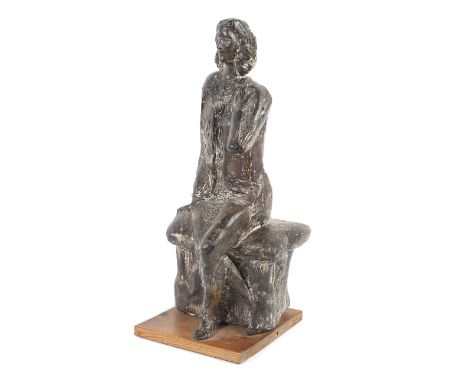A 20th century sculpture of a seated lady.  In the style of Elisabeth Frink, she cast with her left arm raised to her chest, 