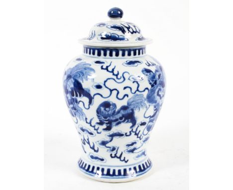 A Chinese porcelain blue and white baluster vase and cover. With spurious Kangxi four character mark, painted with lion dogs 