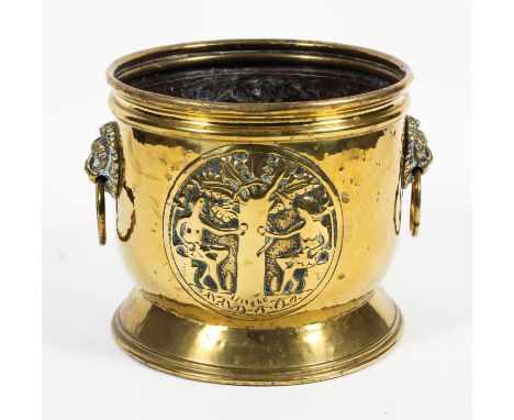 A 19th century brass coal bucket. Cast in relief with Adam and Eve, with lion mask and ring handles, 39cm diam. 