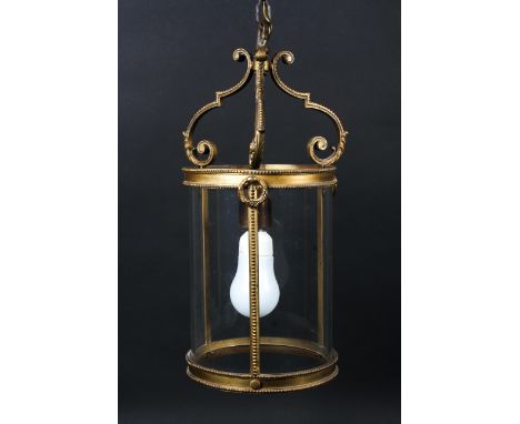 A 20th century gilt metal hall lantern. Of cylindrical form, brass hanging lamp suspended from three scroll brackets, within 