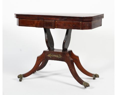 A Regency rosewood fold over brass inlaid card table. The top raised on two shaped supports to a quatrefoil base with outswep