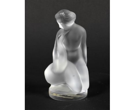 A modern Lalique frosted nude. Etched Lalique/France to side, with Lalique labels, modelled seated embracing a swan, on circu