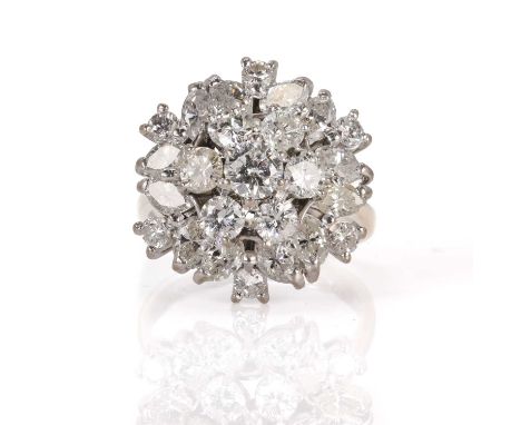 An 18ct white gold diamond set cocktail cluster ring,  with a central cluster of seven graduated brilliant cut diamonds. A lo