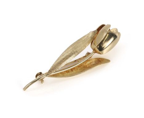A gold tulip shaped brooch, a gently curved tulip, with a plain flower head to textured leaves on either side, to a pin and r