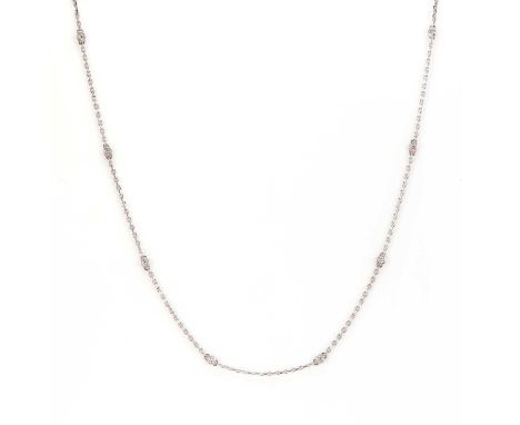 An 18ct white gold diamond station necklace, with round brilliant cut diamonds, bezel set and suspended by sections of cable 