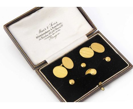 An 18ct gold gentleman's dress studs and cufflinks, comprising a pair of oval cufflinks, with engine turned design and three 