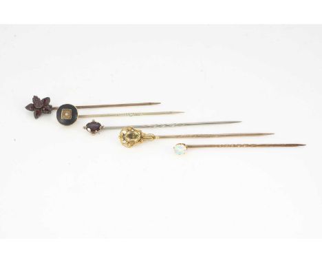 A collection of gem set stick pins, including two garnet, one opal and another citrine, 6g