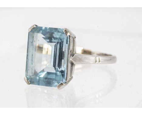 An 18ct white gold topaz dress ring, rectangular mixed cut light blue topaz, in four claw setting, on a plain gold shank, rin