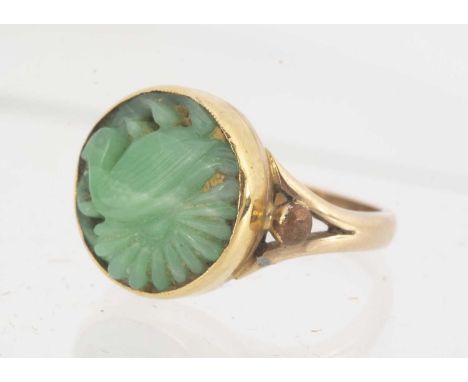 A Chinese jadeite jade carved dress ring, in gilt metal, the carved circular panel depicting a river bird/duck within a flora