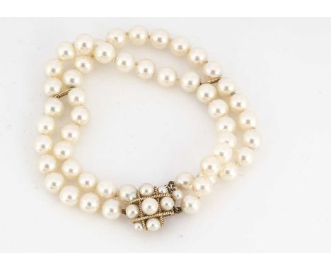 A 14ct gold and cultured pearl double row bracelet, the knotted pearls united by a cluster rope twist tongue and box clasp, w