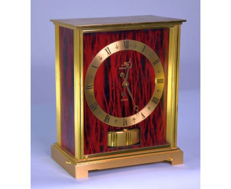 JAEGER LE COULTRE ‘EMBASSY’ ATMOS CLOCK, the 5” gilt Roman chapter ring set on a streaky red and black plate and housed in a 