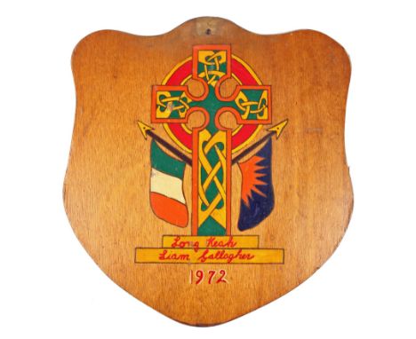 Prisoner Art, Long Kesh 1972, a shield shaped wooden panel painted with a Celtic Cross flanked by an Irish Tricolour and Feni