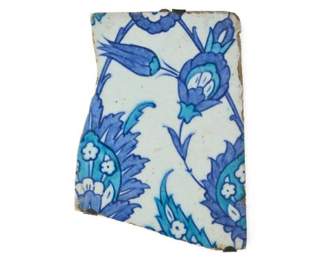 AN IZNIK TILE FRAGMENT, OTTOMAN ANATOLIA, MID-17TH CENTURY  underglaze painted fritware, painted in copper and cobalt blue wi