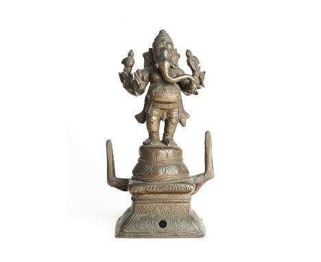 A BRONZE FIGURE OF GANESHA, TAMIL NADU, SOUTH INDIA, CIRCA 18TH CENTURY the four-armed elephant-headed deity standing on a ra