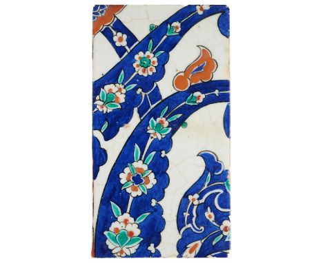 AN IZNIK TILE FRAGMENT, OTTOMAN ANATOLIA, 1570-1580  underglaze painted fritware, decorated with bold interwoven cobalt flora