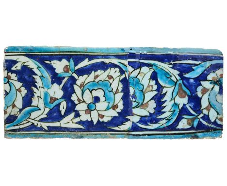 AN IZNIK BORDER TILE, OTTOMAN ANATOLIA, 17TH CENTURY  underglaze painted fritware, composed of two sections joined together, 