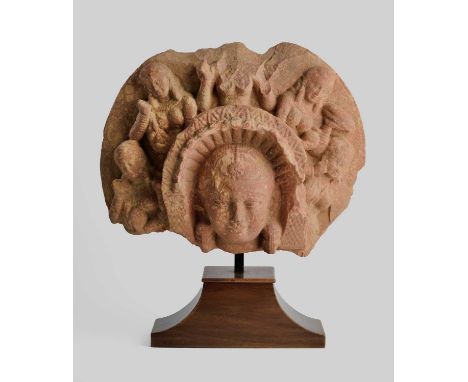 A MOTTLED PINK SANDSTONE FRAGMENT DEPICTING THE MATRIKA SHASHTHI, MATHURA, INDIA, 2ND/3RD CENTURY  her head with earrings and