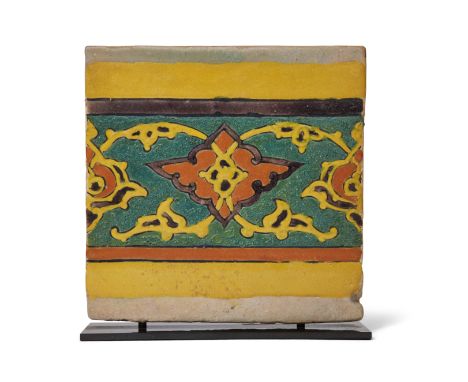 A Mughal cuerda seca border pottery tile, Lahore or Kashmir, India, 17th century, the yellow, orange and aubergine painted de