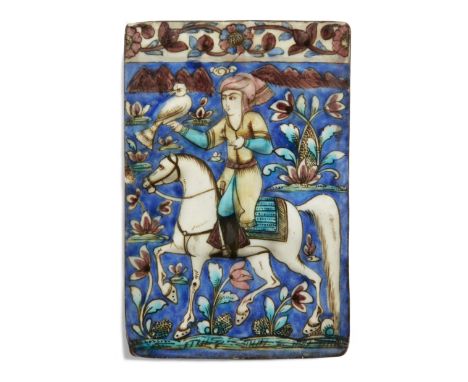 A polychrome moulded pottery tile, Qajar Iran, 1890-1900, of rectangular form, the depicting a turbaned horseman hawking in a
