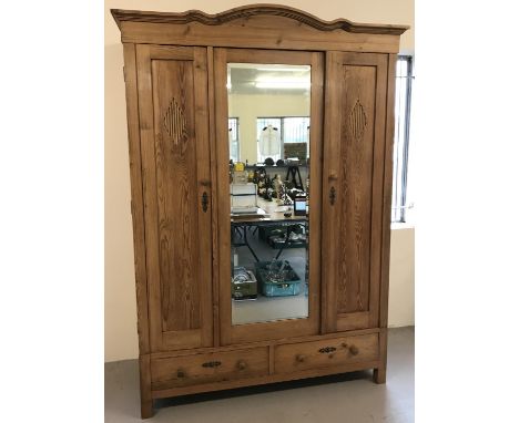 A vintage pine 3 door 2 drawer wardrobe. 2 doors with diamond pattern detail on either side of a larger mirrored door. 2 draw