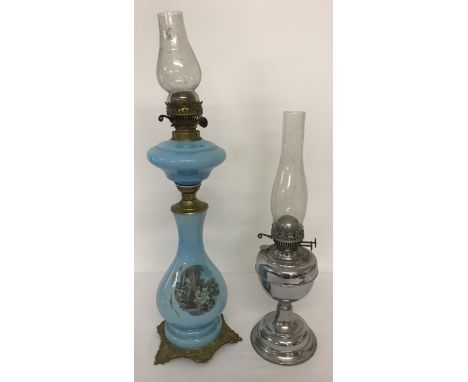 A vintage blue glass 2 tier oil lamp with transfer printed detail to lamp base and decorative cast metal tripod feet. Togethe