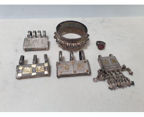 Four Middle Eastern white metal Amulet/Koran Holder style Pendants, a bangle and a Finger Ring set carved red stone