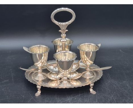 A Victorian silver oval Egg Cup Stand with central handle fitted four egg cups, London 1898, and four Egg Spoons, Birmingham 