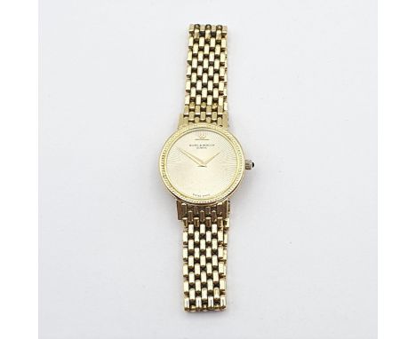 An 18ct gold Baume et Mercier lady's Wristwatch, the gold engine-turned dial having no markers and dauphine hands, set caboch
