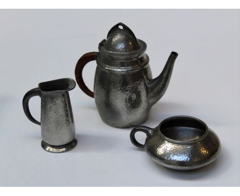 Tudric, a hammered pewter teapot with helmet cover and cane bound loop handle, 19cm, numbered 0232, together with a similarly