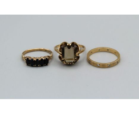 A selection of three 9ct gold rings, one a smoky quartz set cocktail ring, size S, an eternity ring set with cubic zircona, s