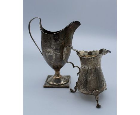 Possibly Richard Ferris, an early 19th century silver helmet shape pedestal cream jug with elongated ribbed handle, armorial 