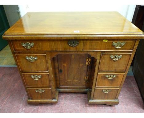 A GEORGE III & LATER WALNUT KNEEHOLE WRITING DESK having a rectangular top with line inlay over a veneered moulded edge, sing