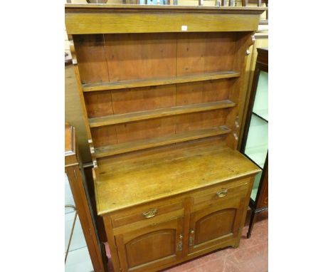 A VINTAGE OAK DRESSER having a three shelf Delft rack with shaped decoration on a moulded edge top with two chamfered frieze 