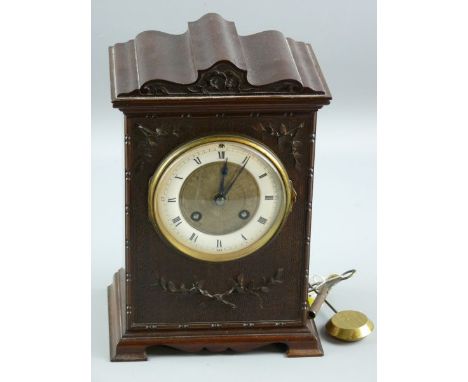 A CIRCA 1900 CARVED MAHOGANY MANTEL CLOCK, the shaped top case with leaf and floral front decoration on a bracket plinth with