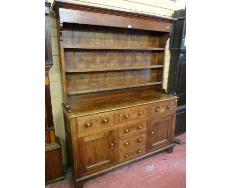 A MID 19th CENTURY OAK WELSH DRESSER with a three shelf rack over a base of two opening centre drawers, two false drawers bel