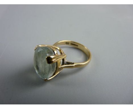 A NINE CARAT GOLD LADY'S DRESS RING with large oval light aquamarine stone, approximately 1.35 x 1 cms, 4.5 grms