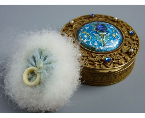 A BRASS FILIGREE & ENAMEL COMPACT, a 4.5 cms diameter lidded box with interior mirror and powder puff, decorated to the top w