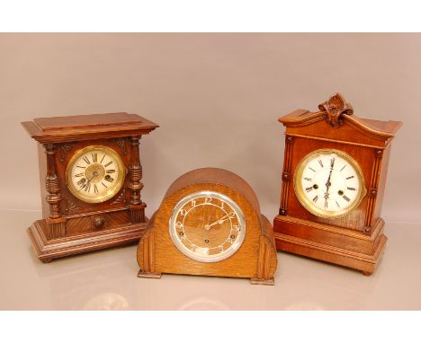 A group of three mantle clocks, comprising two 14 day striking German clocks, in mahogany and oak cases, together with an art