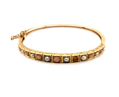 A VINTAGE CORAL AND PEARL SCROLL WORK HINGED BANGLE WITH PUSH CLASP CLOSURE, COMPLETE WITH SAFETY CHAIN. UNHALLMARKED AND ASS