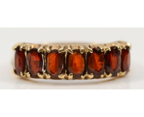 A 9ct gold garnet seven stone ring, Birmingham 1978, M, 2.5g