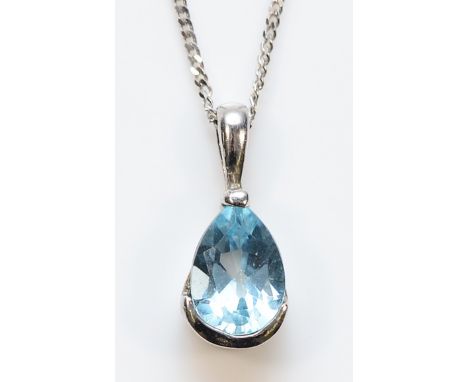 A 9ct white gold blue topaz pendant on a chain, 1.4g
