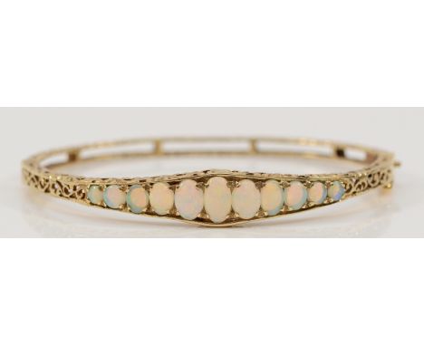 A 9ct gold hinged opal and openwork bracelet, largest opal measures 8mm x 4mm, very good colour play, 60mm diameter, 11.4g