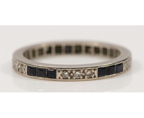 An unmarked 18ct white gold diamond and sapphire full eternity ring, N, 2.8g